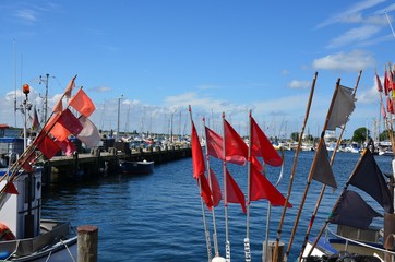 Fototapeta na wymiar Rote Fahnen im Hafen - Fischerei - Fischerboote