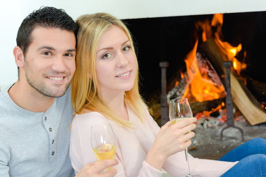 Couple Drinking Wine In Front Of Fire