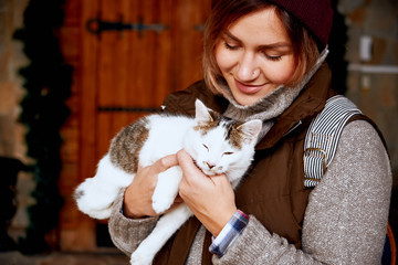 Cat in the hands of girl volunteer, in shelter for homeless animals. Pets 