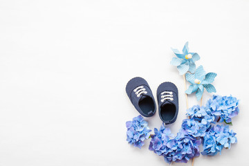 Cute newborn baby boy shoes with festive decoration. Baby shower, birthday, invitation or greeting card mockup