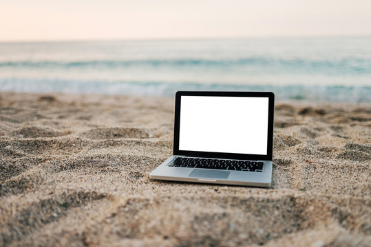 Laptop on the sand beach. - Powered by Adobe