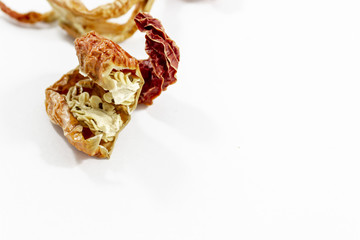 Detail close-up shot for dried orange colored pepper with blurry white background