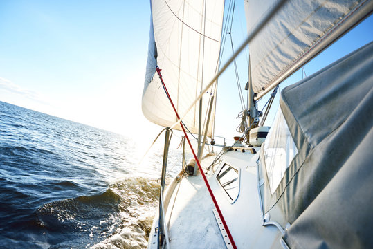 Fototapeta Close-up of the yacht in the sea, a view from the deck to the bow and sails. A clear sunny day, Latvia