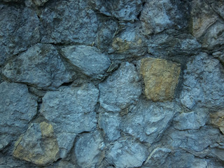 Stones in a blue and yellow wall
