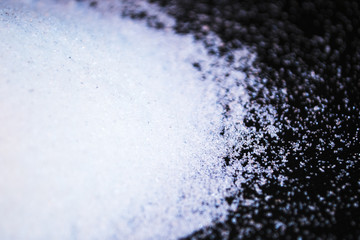 Spilled white sugar on a black background.