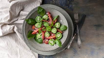 Vegetable salad of red and green tomatoes with basil leaves. Top view