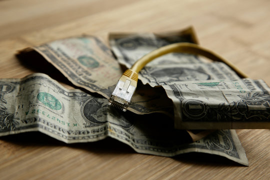 The cost of internet data plans in America concept image consisting of USA dollar bills and an Ethernet cable.  This image can also be used to represent net neutrality or online income. 