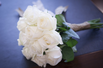 Wedding white bouquet of roses in the hands of the bride