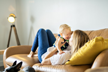 happy family. Mother and baby daughter plays, on the sofa