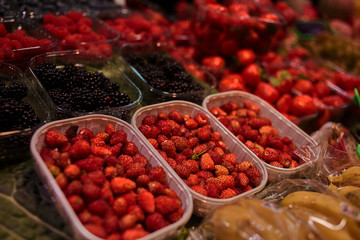 Summer organic berries on display. Agriculture, gardening, harvest concept. Strawberries, raspberries, blueberry for sale at the farmers' market. Ecological berries for desserts. Selective focus.