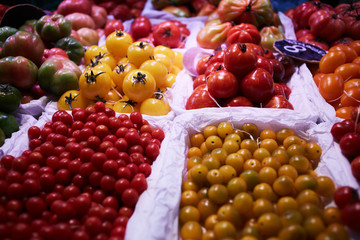 Various summer vegetable. Tray of fresh different kinds of tomatoes on display at a local market. Fresh organically grown vegetables from village garden. Agriculture, gardening, harvest concept.