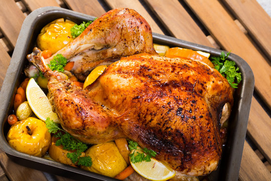 Image of tasty  homemade turkey with apples, lemon and greens