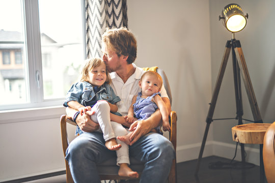 Portrait of happy son and baby daughter with father at home