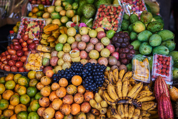 Asian exotic fruits. Market stall with variety of organic fruits. Colorful fruits in the marketplace. Bright summer background. Healthy, organic food. Natural nutrition for diet. Selective focus.