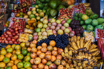 Naklejka na ściany i meble Asian exotic fruits. Market stall with variety of organic fruits. Colorful fruits in the marketplace. Bright summer background. Healthy, organic food. Natural nutrition for diet. Selective focus.