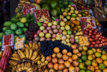 Asian exotic fruits. Market stall with variety of organic fruits. Colorful fruits in the marketplace. Bright summer background. Healthy, organic food. Natural nutrition for diet. Selective focus.