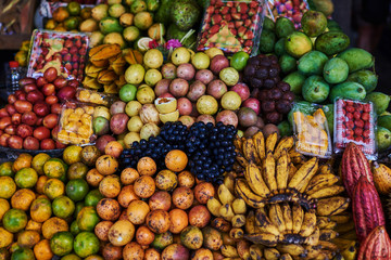 Asian exotic fruits. Market stall with variety of organic fruits. Colorful fruits in the marketplace. Bright summer background. Healthy, organic food. Natural nutrition for diet. Selective focus.