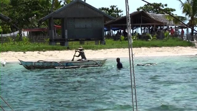 Tourist boats arriving at Pamilacan island and being greeted by local fishermen selling their fresh goods.