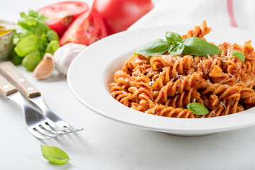 Fusilli pasta with tomato sauce, garlic, Basil and Parmesan cheese on white background