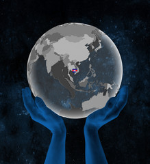 Cambodia on globe in hands in space