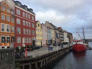 Naklejka premium Piękne widoki na kanał, brzeg z domkami, jachtami, żaglówkami i barkami. Zachód słońca przy pochmurnej pogodzie. 30 stycznia 2018 r. Nyhavn, Kopenhaga, Dania.