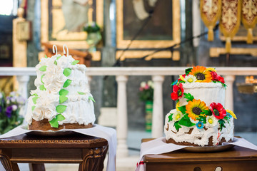 White wedding cake with flowers and leaves on black background isolated.
