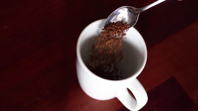 here you see the dried coffee being poured into a cup, before putting how water in the cup to complete the drink.