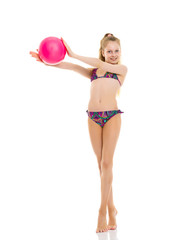 Little girl in a swimsuit with a ball