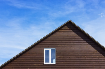 Fototapeta na wymiar Top Of A Wooden Plank House Against The Sky