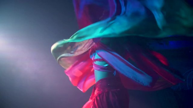 Beautiful woman performs a scarf dance in slow motion