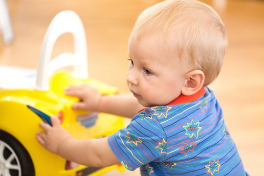Portrait of a Cute Baby with a Toy Car