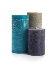 Different decorative wax candles on white background