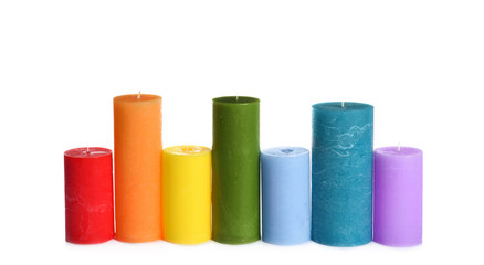 Different colorful wax candles on white background