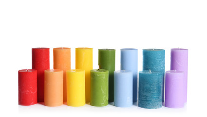 Different colorful wax candles on white background