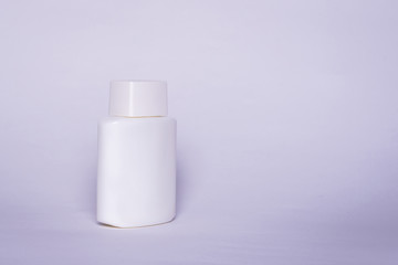 Isolated white bottle on a light gray background. A bottle with an empty space ready to be completed in the form of a mock-up.