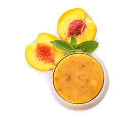 Tasty peach smoothie in glass and fresh fruit on white background, top view