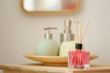 Obraz na płótnie Canvas Aromatic reed air freshener and toiletries on table indoors