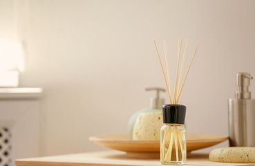 Fototapeta na wymiar Aromatic reed air freshener and toiletries on table indoors