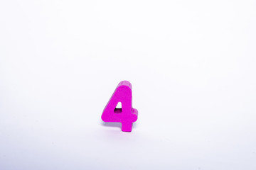 Pink digit 4 isolated on a white background. Wooden number 4 on a white background.