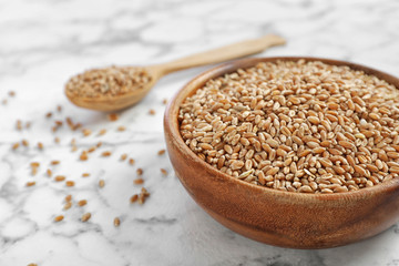 Bowl with wheat on marble table. Grains and cereals