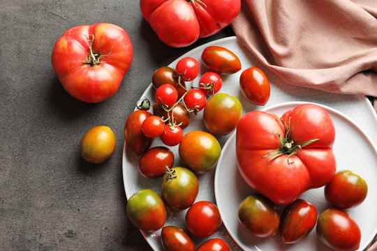 Flat lay composition with juicy tomatoes on grey background