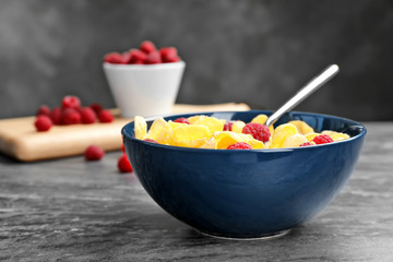 Bowl with cornflakes and milk on dark table. Whole grain cereal for breakfast