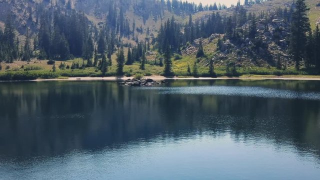 Drone shot gliding along Lake Catherine in Alta, Utah.