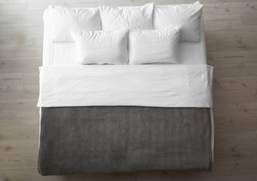 Comfortable bed with soft pillows indoors, top view
