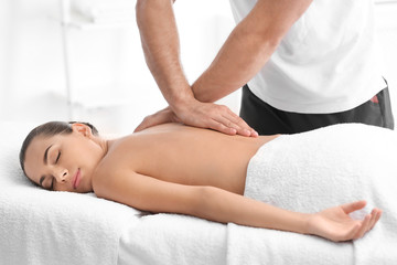 Fototapeta na wymiar Relaxed woman receiving back massage in wellness center