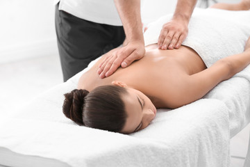 Fototapeta na wymiar Relaxed woman receiving back massage in wellness center