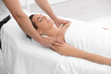 Fototapeta na wymiar Relaxed woman receiving shoulders massage in wellness center