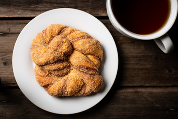 Hot Tea and Cinnamon Sugar coated Danish on White Plate