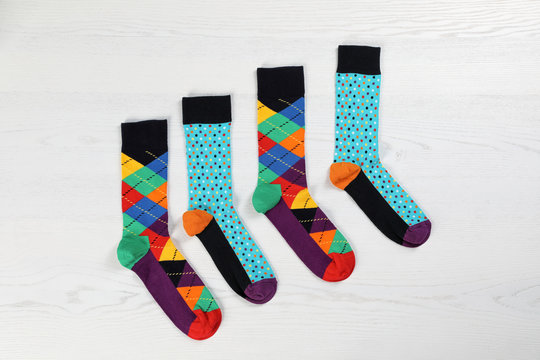 Flat lay composition with different socks  on light wooden background