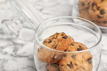 Jar with chocolate chip cookies on table, closeup